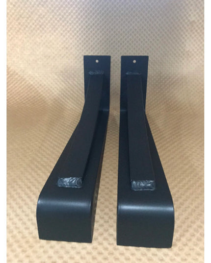 Two black metal Saratoga Shelf Support Brackets by Industrial Farm Co displayed on wood surface, showing curved design and...