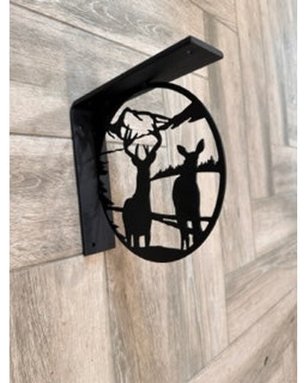 Black metal L-bracket shelf support featuring laser-cut deer and tree silhouette design by Industrial Farm Co, mounted on ...