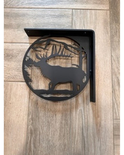 Black metal L-bracket shelf support featuring handcrafted elk silhouette cutout design mounted on light wood planked wall ...