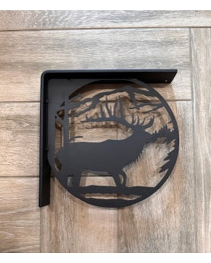 Black metal L-bracket shelf support with decorative elk silhouette cutout design mounted on rustic wood planks by Industri...