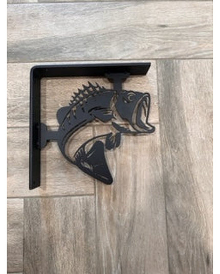 Black metal shelf bracket with bass fish design featuring spiky dorsal fin and open mouth, mounted on light wood backgroun...