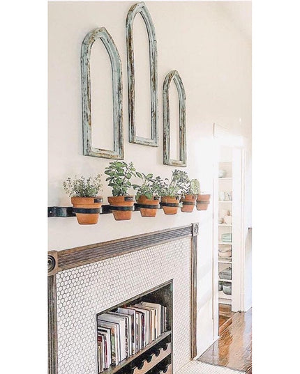 The Yonkers Horizontal Steel Planter by Industrial Farm Co holding terracotta pots with herbs on white fireplace mantel